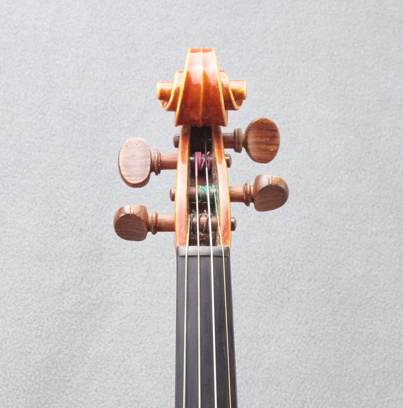 The scroll of a James Stephenson Violin (2016) with beautiful handmade varnish (front view).
