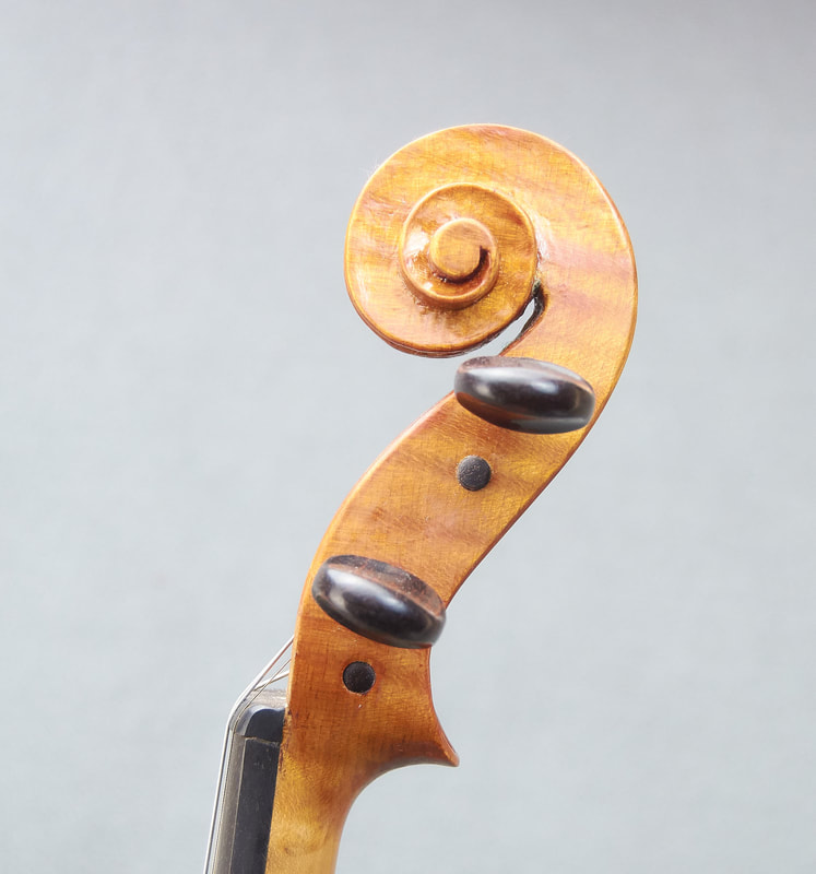 The scroll of a handmade violin by Libby Summers (side view).
