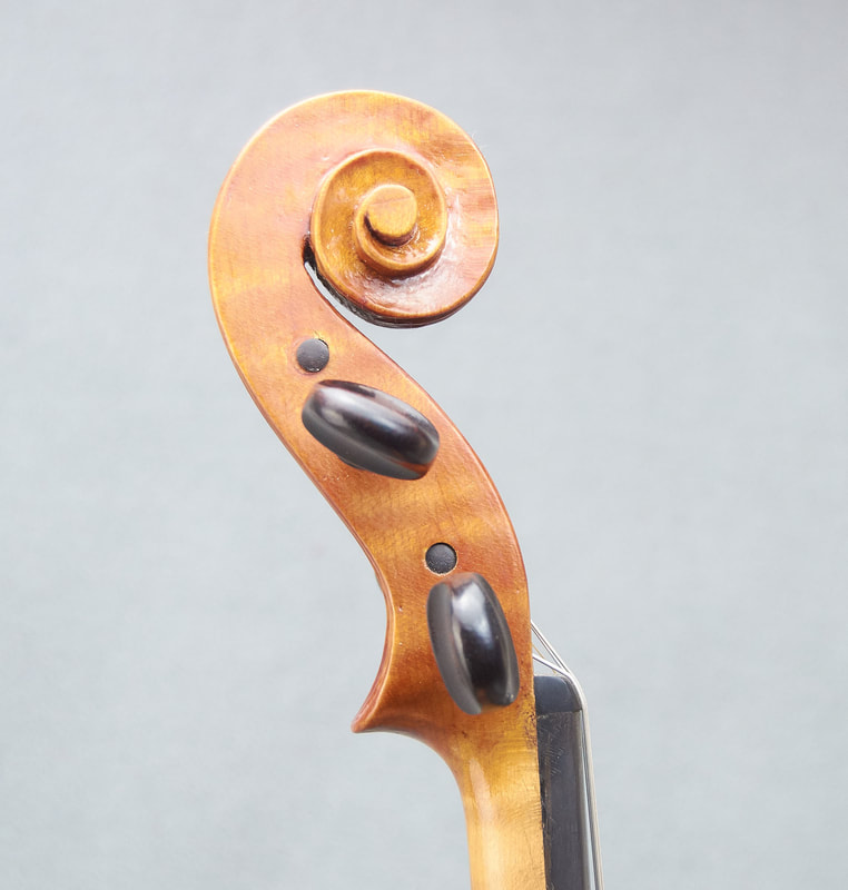 The scroll of a handmade violin by Libby Summers (side view).