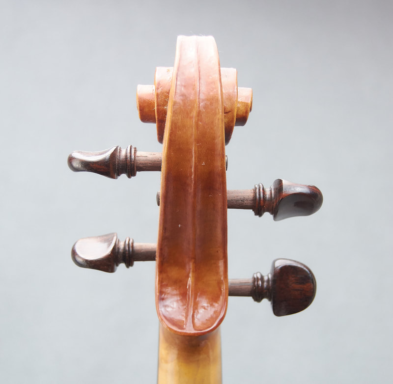The scroll of a handmade violin by Libby Summers (back view).