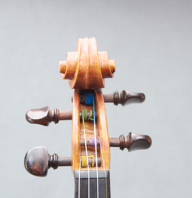 The scroll of a handmade violin by Libby Summers (front view).