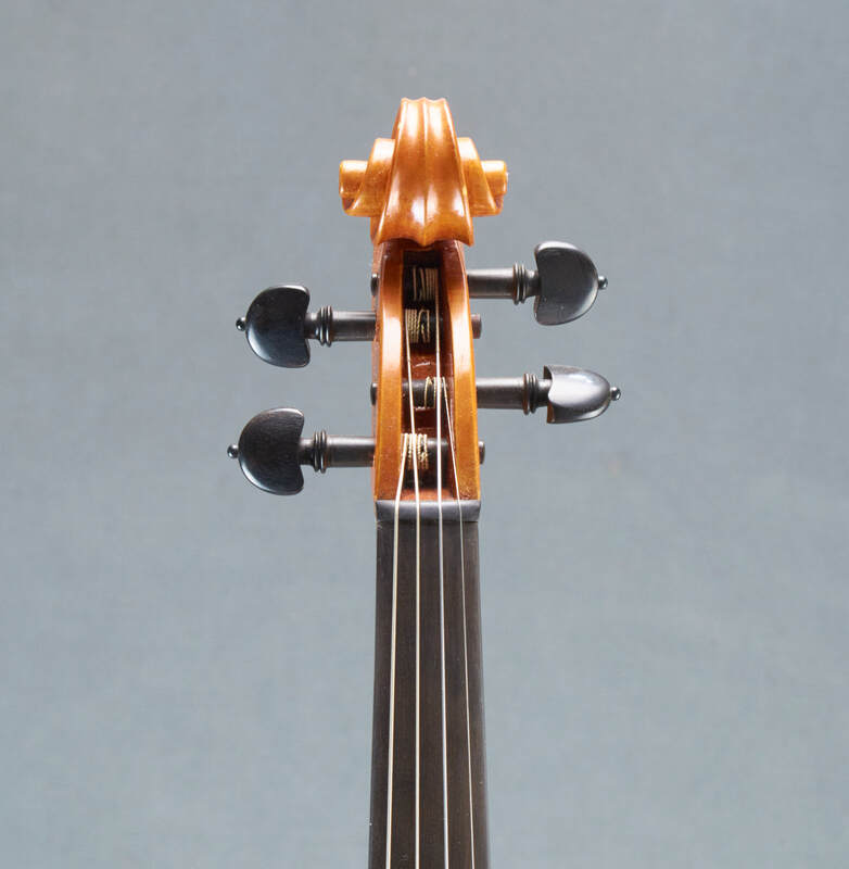 The scroll of a beautiful, handmade Tj Geever Violin (front view).