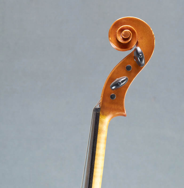The scroll of a beautiful, handmade Tj Geever Violin (side view).