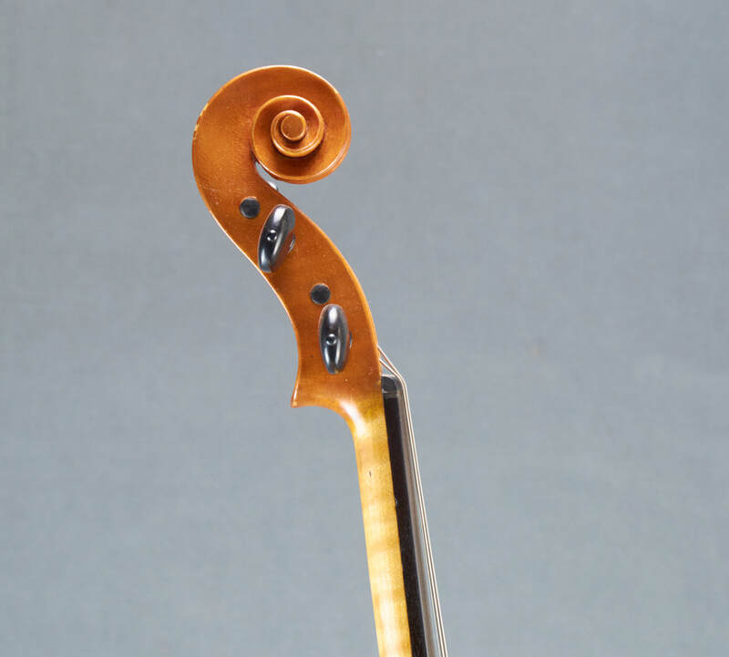 The scroll of a beautiful, handmade Tj Geever Violin (side view).