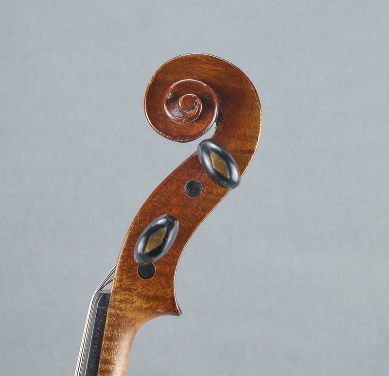 The scroll of a French, Antique Violin (1900) handmade with lovely warm tone (side view).