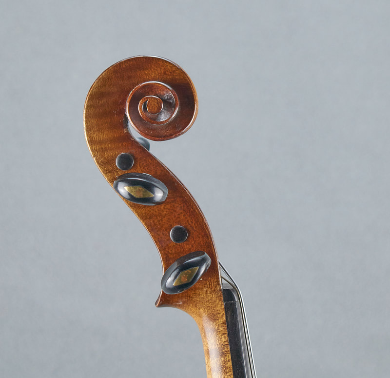 The scroll of a French, Antique Violin (1900) handmade with lovely warm tone (side view).