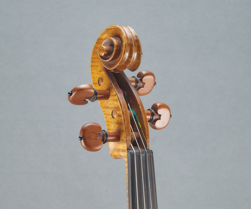 The scroll of an antique, handmade Mirecourt Violin (1890) with stunning flamed maple (front view).